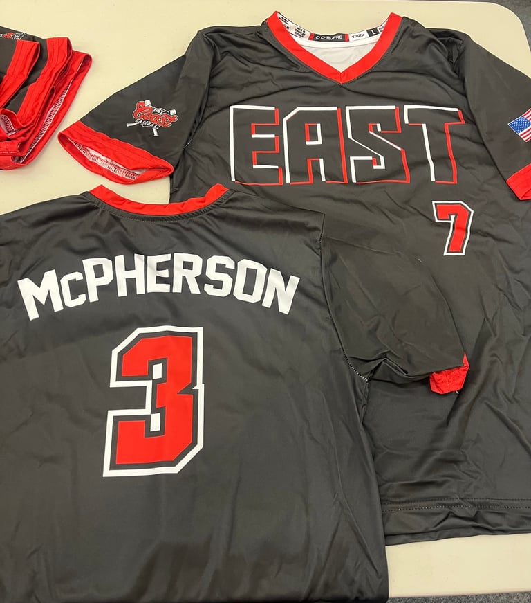 Two black and red sports jerseys, one displaying McPherson number 3 and another East number 7, laid on a light surface