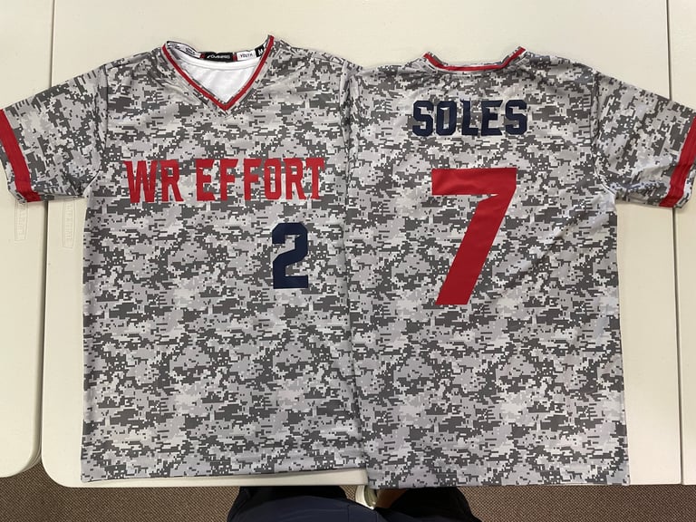 Two gray and red digital camouflage baseball jerseys displaying number 2 and number 7 with player names Lakeford and Soles