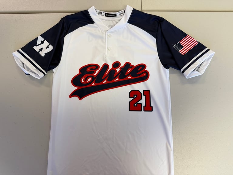 White and navy baseball jersey with Elite script and number 21 in red, featuring American flag patch on sleeve
